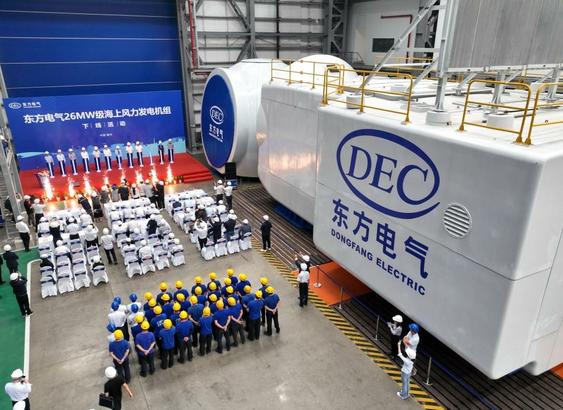 Factory workers and nacelle at ceremony in production hall.