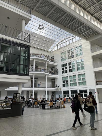 Students are sitting and walking through the Mechanical Engineering building at the Technical University of Munich.