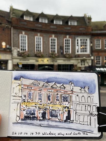 A curved building with a coloured sketch of it in front.