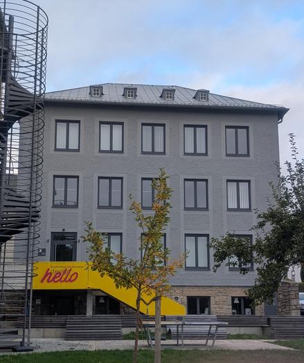 Building with a yellow stairwell and a "hello" graffiti.