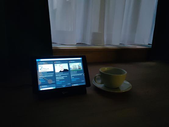 Veranstaltungsticker auf dem Tablet eines Hotelzimmers. Daneben ein Kaffeetasse.