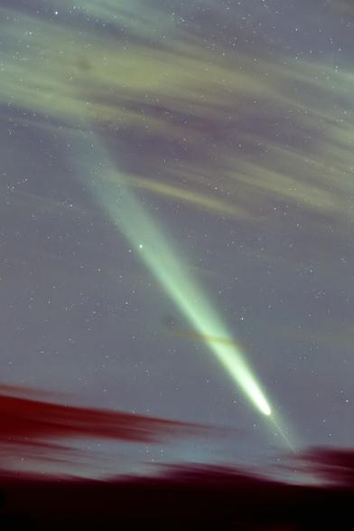 Stark bearbeitetes Bild des Kometen zwischen Wolken, bei dem man den Gegenschweif nun deutlich besser erkennen kann. Er ist als zur Sonne (nach rechts unten) weisende Spitze am Kometenkopf sichtbar.

Heavily processed image of the comet between clouds, in which the anti-tail can now be seen much better. It is visible as a sharp linear feature at the comet's head pointing towards the sun (down to the right).