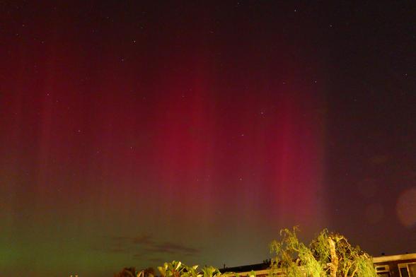 De foto laat verticale dieprode banen poollicht zien, dat zichtbaar was in de vroege ochtend van 11 oktober. In de nacht van 10 op 11 oktober was boven grote delen van de wereld spectaculair poollicht zichtbaar, veroorzaakt door elektrisch geladen deeltjes die enkele dagen eerder bij een enorme uitbarsting op de zon de ruimte ingeblazen waren.
