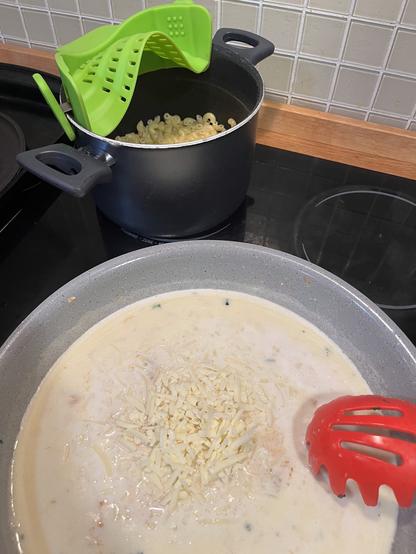 el mismo sartén preparando la salsa de queso (con la pasta cocida en una olla en el fondo de la foto)