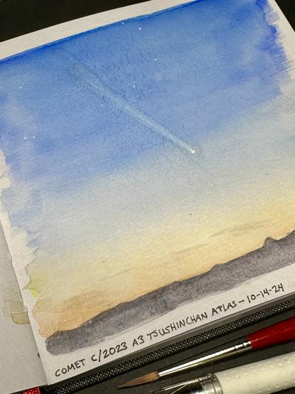 A watercolor on gray toned paper of the evening sky, scant clouds lit faintly with sunset, looking west across the Rogue Valley in southern Oregon. A range of mountains crosses the bottom of the scene. High above is a faint comet with a long tail stretching towards the upper left corner. A sprinkling of stars appear in the deepening sky.