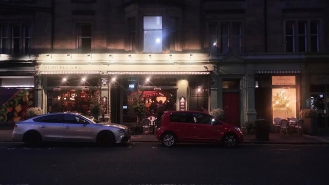 Looking across Bruntsfield Place at night towards the brightly lit signs above Montpelliers bar and restaurant