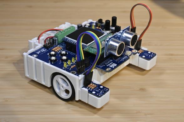 A white 3D-printed BEAPER Bot robot controlled by a Raspberry Pi Pico W microcontroller in a BEAPER Pico PCB.