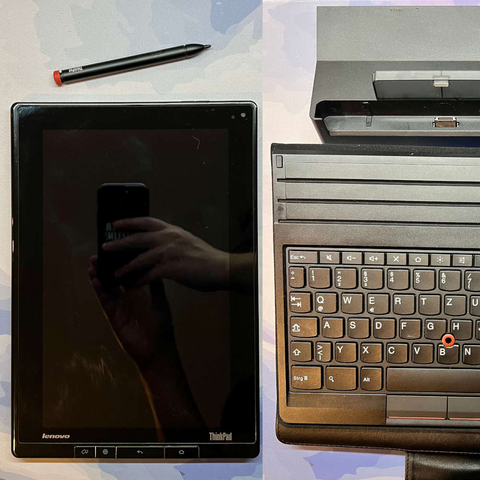 Ein Foto eines Tablets mit "Lenovo ThinkPad"-Logo. Darüber ein Digitizer-Stift. Neben befinden sich eine Docking-Station sowie ein Schutzgehäuse mit Tastatur.
