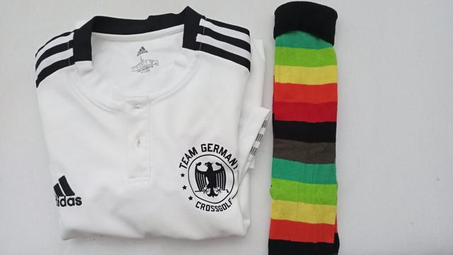 Ein Crossgolf Nationaltrikot und Ringelstrümpfe in Regenbogenfarben, liegen auf einem Bett, bereit für den Einsatz