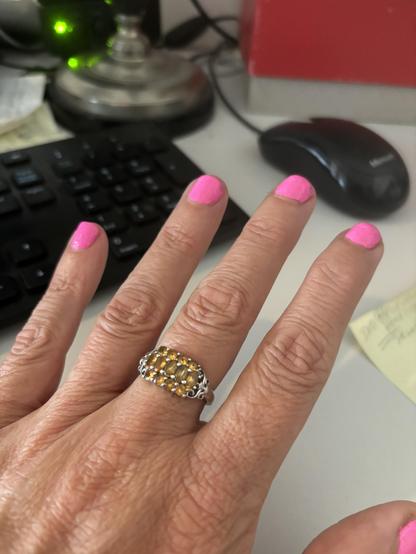 A man’s left hand is seen. The short fingernails have been painted hot pink.