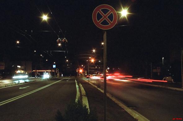 Nachtaufnahme auf Stativ - Via Laurentina in Rom mit wenig Verkehr gegen 22 Uhr. Rechts die verwischten roten Rücklichter von Autos, links weiße Scheinwerfer. Oben der sternförmige Schein von Straßenlampen. Leica R5 mit 50 mm Summilux auf Lomography 800er-Farbfilm.