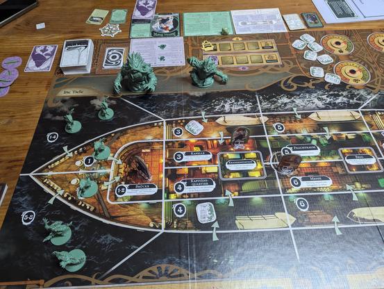 Game board with figurines, standees and tokens. Cards next to the board