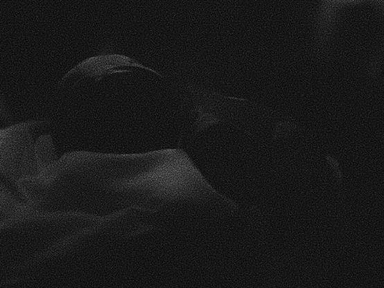 A photo of my two-week-old son being very cute. The photo is purposefully grainy and dark and it’s very difficult to see anything.