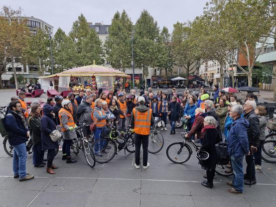 Photo du rassemblement sur la place de la mairie à Malakoff, une cinquantaine de personnes rassemblées avec leurs vélos observent une minute de silence sous un ciel gris.
