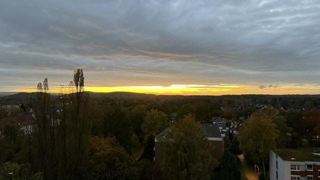 The sun has set but there is still a strong golden light between the horizon and the cloud cover.
