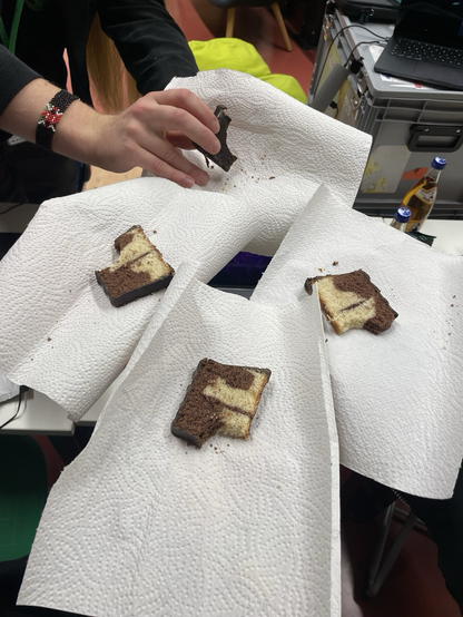 4 angebissene Kuchen die auf Kuchenpapier in die Lift gehalten werden.