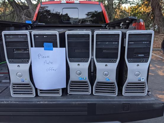 A handful of Dell computer towers on a truck tailgate with a sign: "please make offer"