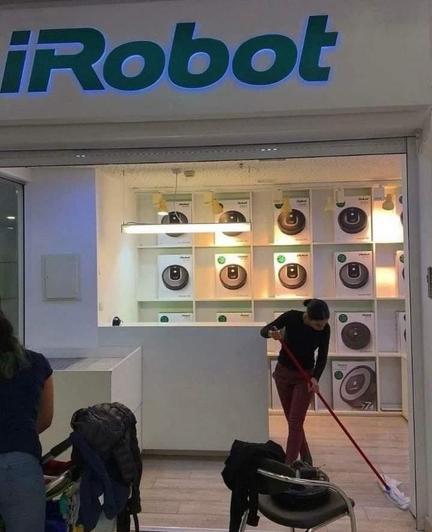 human cleaning a store room selling iRobot room cleaners