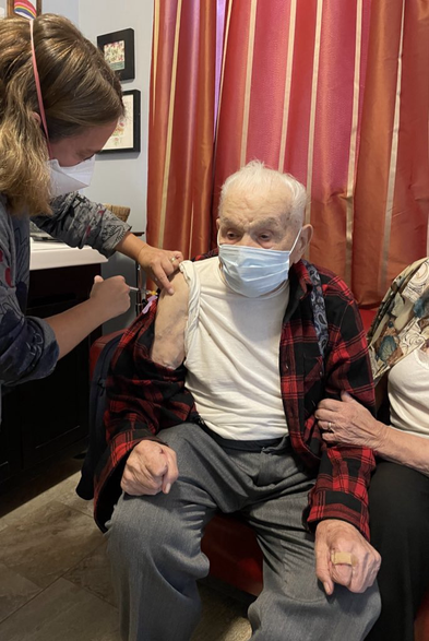 Giving Covid booster to 104 year old patient