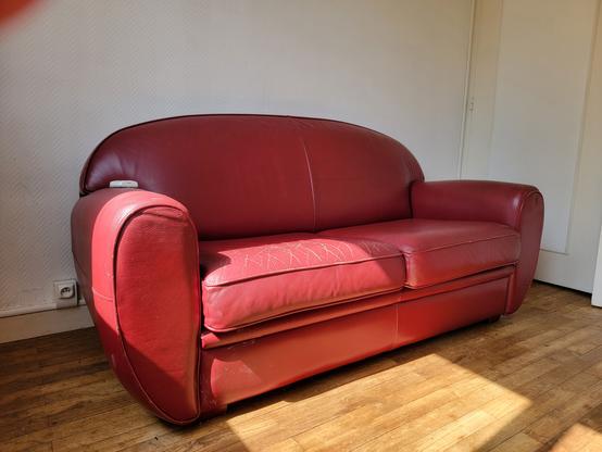 Un canapé en cuir rouge baigné de lumière
