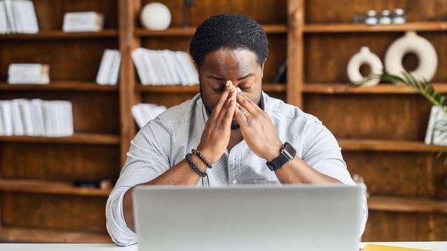 photo - frustrated job seeker sitting at his laptop