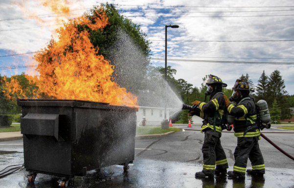 photo - fireman putting out a (literal) dumpster fire
