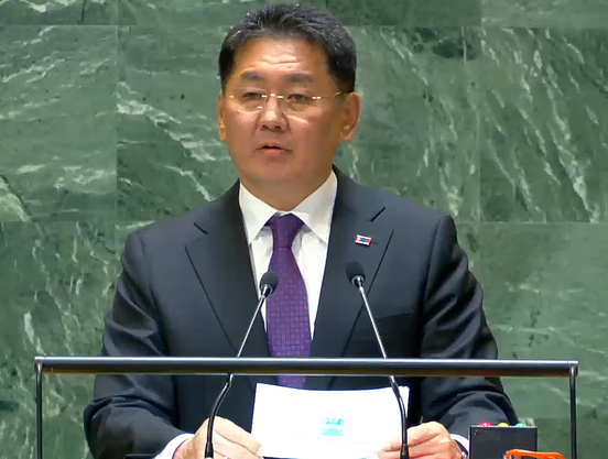 Screnshot taken from video recording of Pres. Khurelsukh's speech. Khurelsukh appears in front of the dark green tiled background of the UN General Assembly dais. He's wearing a dark blue suit with a small lapel pin that appears to be the flag of Mongolia.