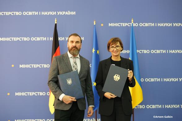 Bundesministerin Stark-Watzinger mit ihrem ukrainischen Amtskollegen Oksen Lisovyi mit den Mappen zum Abkommen zur Wissenschaftlich-Technischen Zusammenarbeit
