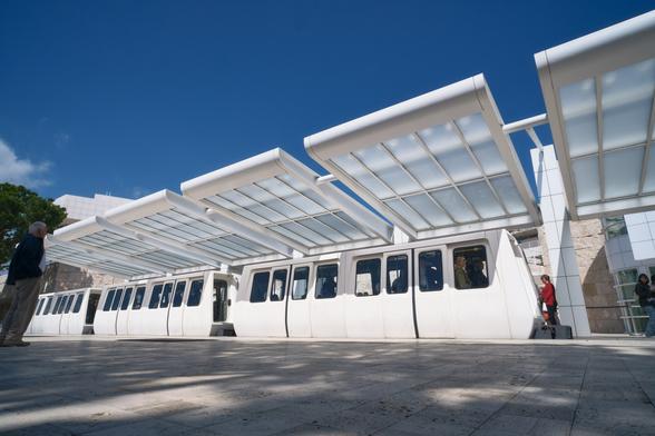 A small tram under a rectangular roof structure