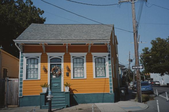 A cute little house painted cold and green with white trim on the door frame and windows.