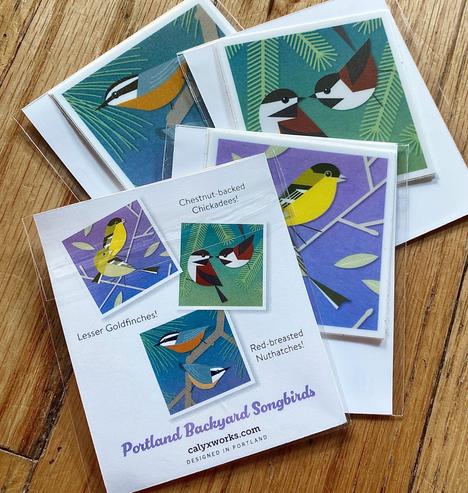 Photo of three small packets of square stickers, colorful geometric renderings of bird pairs as noted in the main body of the post.