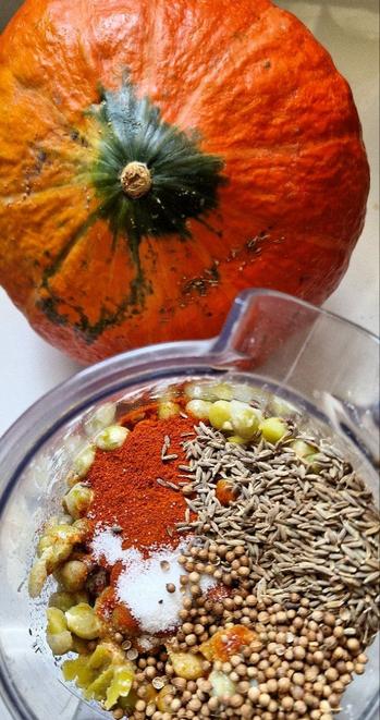 Ein Hessischer Hokkaido im Hintergrund, vorn gekochte grüne Erbsen mit Tahin, Leiöl, Zitronensaft, edelsüßem Paprika, Koriandersaat, Kreuzkümmel, Chilli, Salz im Mixbecher.