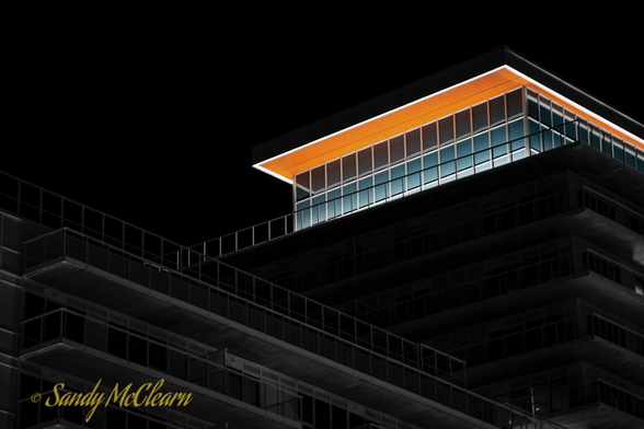 Orange penthouse roof over black and white building.