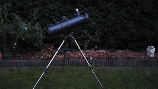 Ein Celestron-Spiegelteleskop steht im dämmrigen Garten.