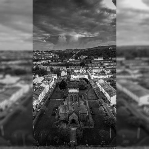 Monochrome aerial shot of church set in grass area in town centre