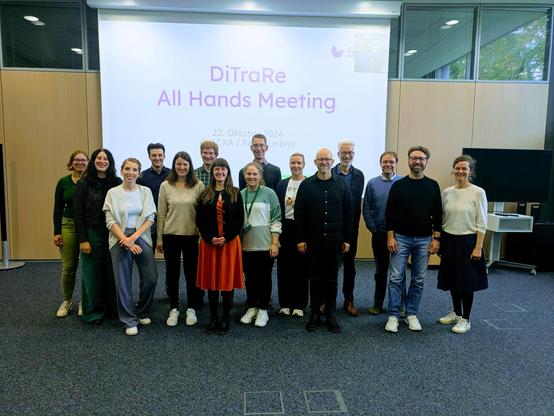 A group picture of the whole DiTraRe consertium in front of the presentation screen.