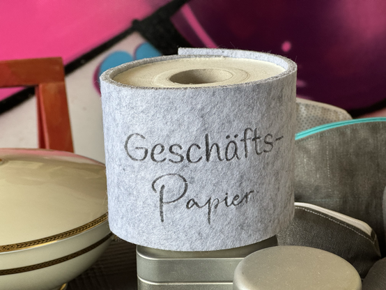 Eine Rolle Toilettenpapier beschriftet mit “Geschäfts-Papier”.