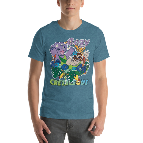 Image shows a figure wearing a heather teal tshirt that has a cute triceratops and a sloth dancing with their arms up and smiling wide, around some beautiful foliage and flowers. The sloth has a flower in their head-fur and the words "Cozy con" are on the top right, and "Cretaceous" centered along the bottom.