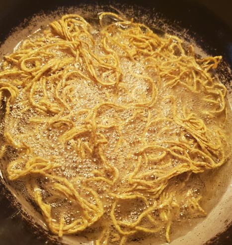 Chow mein, being deep fried in wok