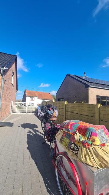 The fully packed bicycle and colorful cart stand ready to leave in the driveway
