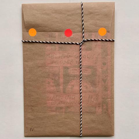 This is the back of the envelope, with the black and white string, and three orange/red stickers that seal the envelope flap.