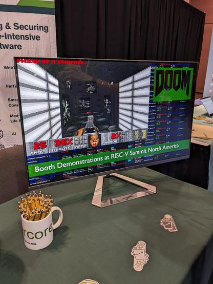 A computer monitor in the expo hall demonstrating the video game Doom running on a RISC-V board