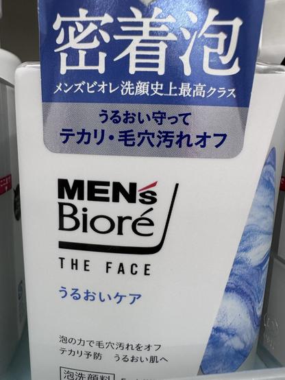 The image shows a bottle of MEN's Bioré facial cleansing product. It features Japanese text, including the product name and descriptions related to skincare benefits, such as removing dirt and preventing acne. The design is predominantly white and blue.