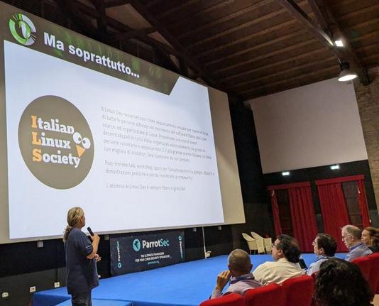 L'attivista Marcello, detto Il Vichingo, che vi garandisco che sia bellissimo e biondissimo e molto vichingo, mostra una presentazione con un logo enorme di Italian Linux Society. Si nota il partner ParrotSec.