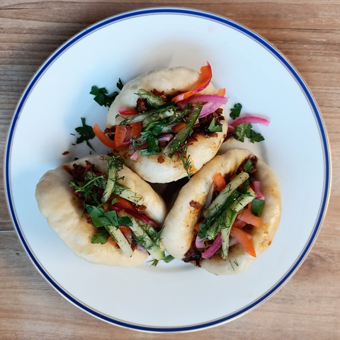 Auf einem Teller drei fertig gefüllte Bao Buns wie im Rezept beschrieben.