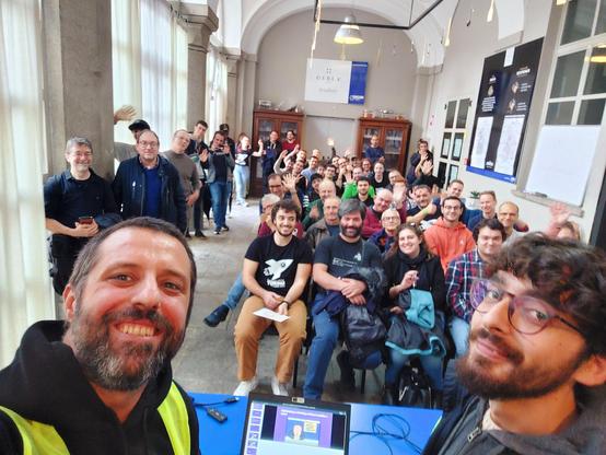A selfie with two persons and the participants at the talk at Linux Day in Torino.