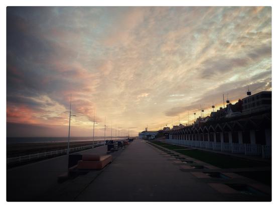 Sunset over a sleepy seaside town that's out of season. Everything feeling muted and waiting to come alive again