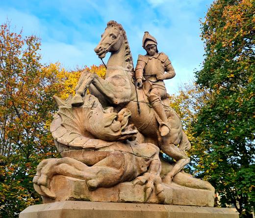 A sandstone sculpture of a mounted Saint George fighting a dragon.