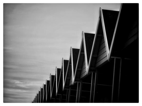 A row of beach huts roofs in black and white