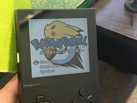 A photo of a black analogue pocket handheld device, sitting at the main menu for the game boy color version of Pokémon Pinball.